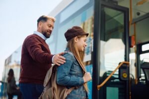 Teacher and teenage female student boarding a city bus