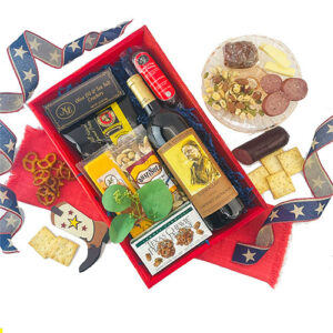 A pleasing display of wine, meats and cheeses in a red box with Texas flare, complete with boot keychain and star spangled ribbons.
