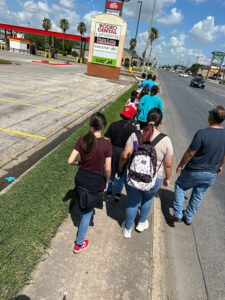students walk down the sidewalk with their teacher during the ecc summer camp in Brownsville 2023