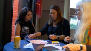 guests sign in with board secretary Beth Pierce